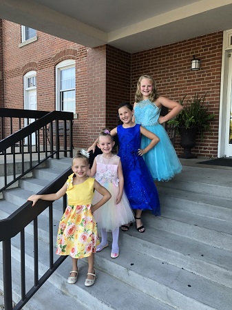 Highfalutin--four young girls in fancy dresses on steps