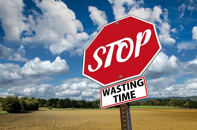 Dillydally-stop sign with a "wasting time" sign below it