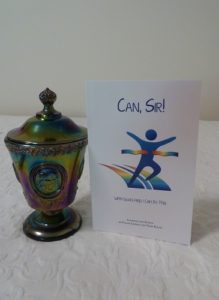 Can, Sir! - Book beside a blue carnival glass dish